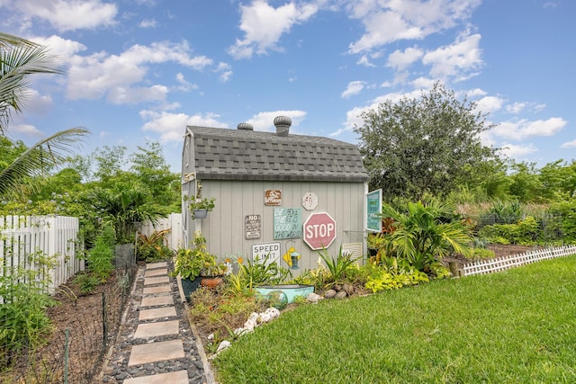 rear view of house with an outdoor structure and a yard