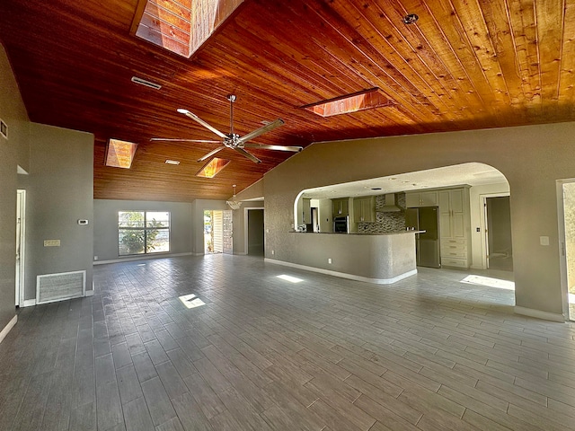 unfurnished living room with wooden ceiling, hardwood / wood-style flooring, ceiling fan, and lofted ceiling with skylight