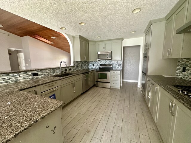 368 Fairgreen Pl, Casselberry, FL 32707 - kitchen featuring a sink, tasteful backsplash, stainless steel appliances, light wood-style floors, and dark stone counters