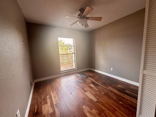 empty room featuring a textured ceiling, wood-type flooring, and ceiling fan