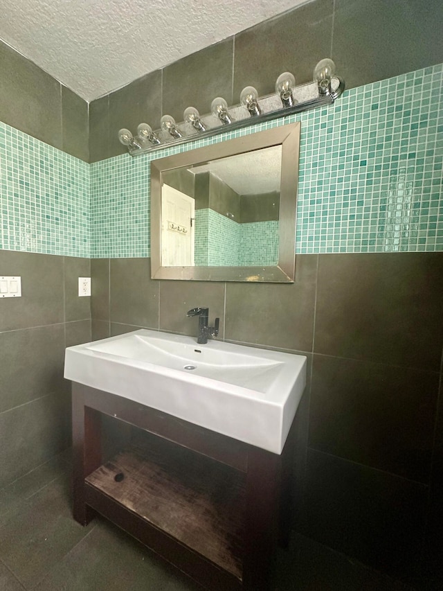 bathroom with backsplash, tile walls, a textured ceiling, and vanity