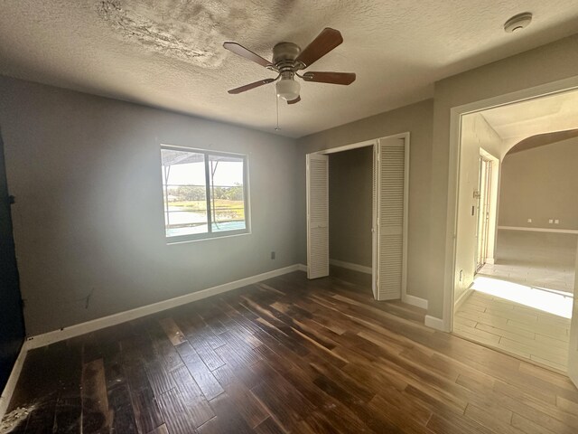 368 Fairgreen Pl, Casselberry, FL 32707 - unfurnished bedroom with baseboards, a closet, arched walkways, and dark wood-type flooring