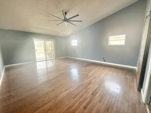 unfurnished room with ceiling fan, lofted ceiling, a textured ceiling, and hardwood / wood-style flooring