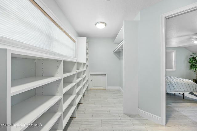 spacious closet featuring wood tiled floor and ceiling fan