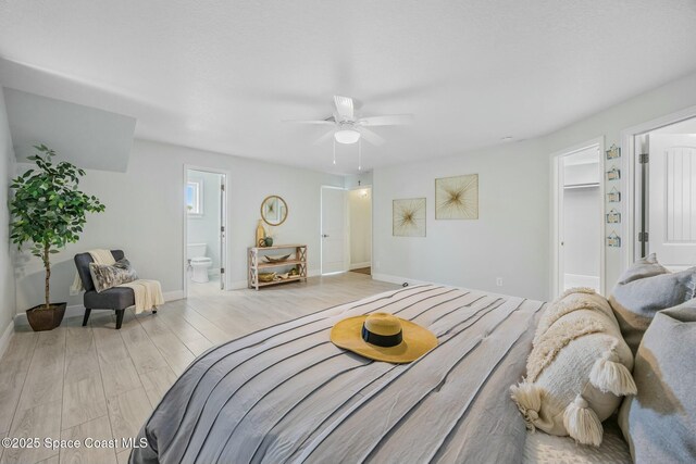 bedroom featuring connected bathroom, light wood-style flooring, and baseboards