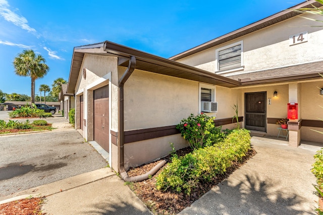 exterior space with a garage and cooling unit