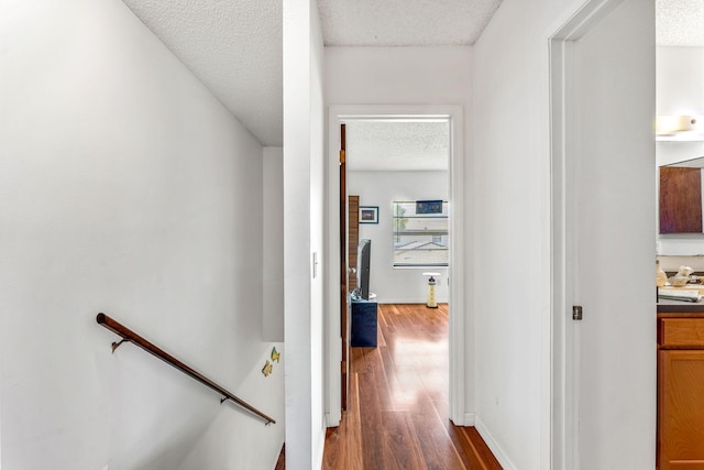 hall with dark hardwood / wood-style flooring and a textured ceiling