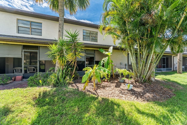 exterior space featuring cooling unit and a front lawn