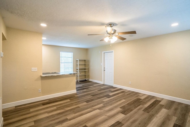 spare room with a textured ceiling, dark hardwood / wood-style flooring, and ceiling fan