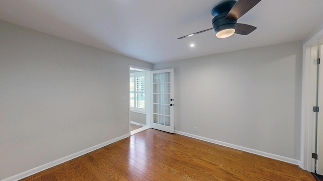 spare room featuring ceiling fan, baseboards, and wood finished floors