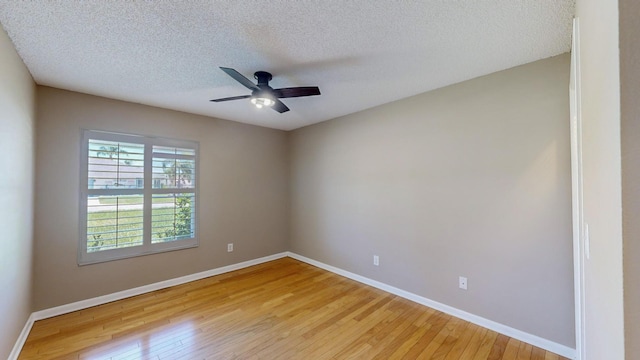 empty room with baseboards, ceiling fan, and light wood-style floors