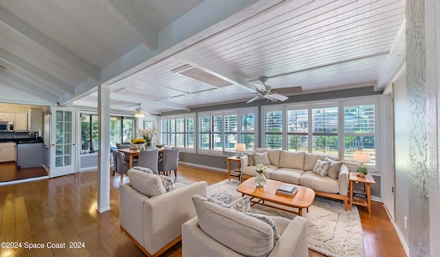 sunroom / solarium with beam ceiling, ceiling fan, and french doors