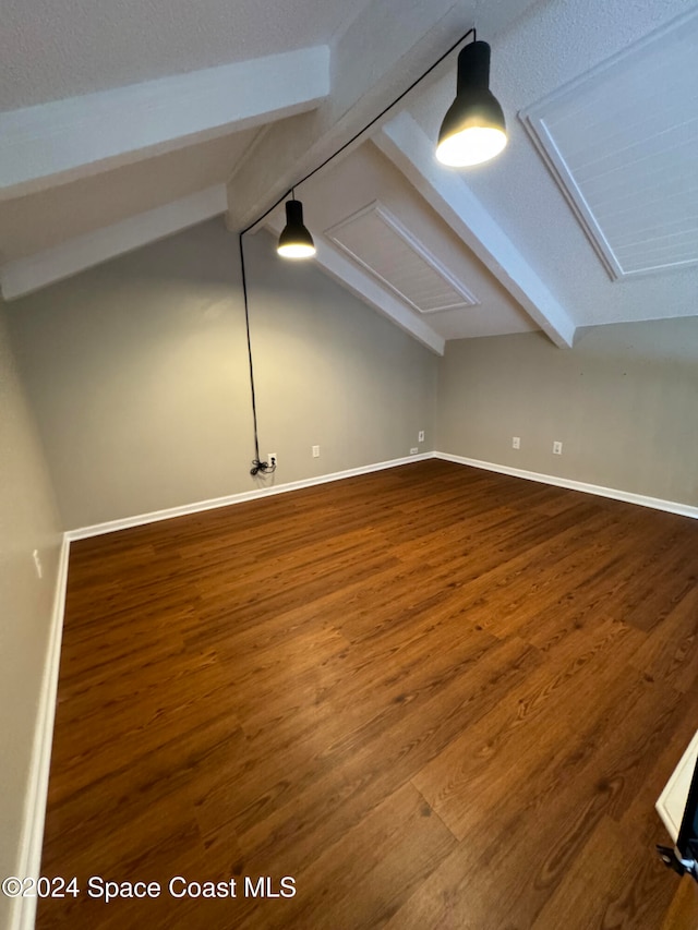 additional living space featuring vaulted ceiling with beams and hardwood / wood-style flooring