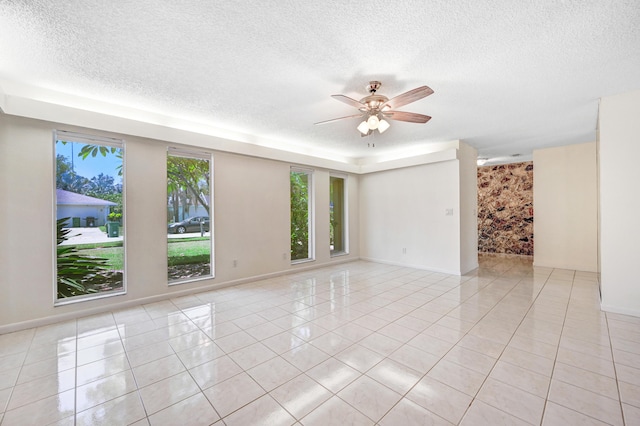 tiled spare room featuring a textured ceiling and ceiling fan