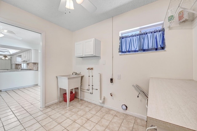 clothes washing area with hookup for a gas dryer, ceiling fan, cabinets, and a textured ceiling