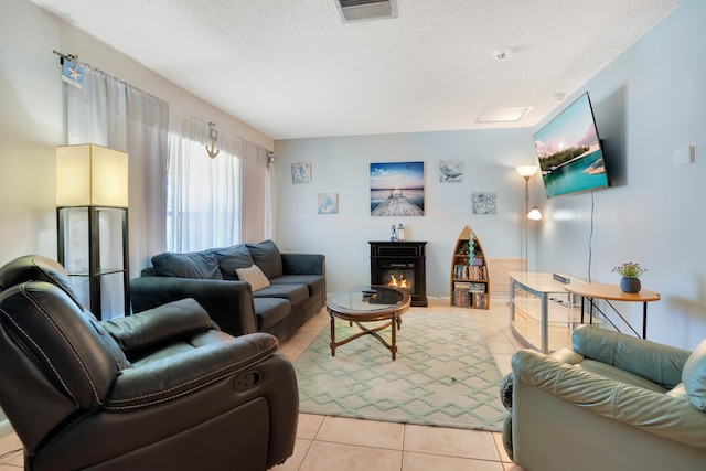 living room with a textured ceiling and light tile patterned flooring