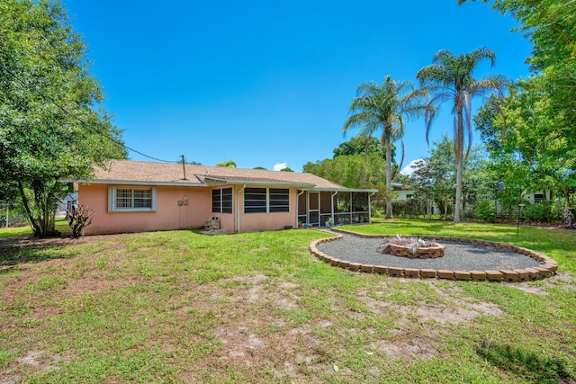 back of house with a sunroom, a fire pit, and a yard