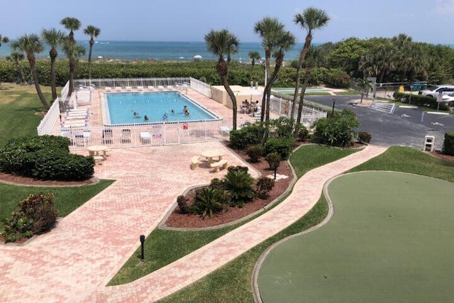 view of swimming pool with a patio and a water view