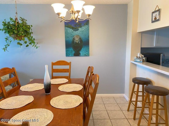 7520 Ridgewood Ave Unit 507, Cape Canaveral, FL 32920 - dining space featuring a chandelier, light tile patterned flooring, and baseboards
