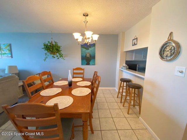 dining room with a textured ceiling, an inviting chandelier, and light tile patterned flooring