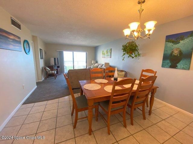 dining room with a textured ceiling, a chandelier, and light tile patterned floors