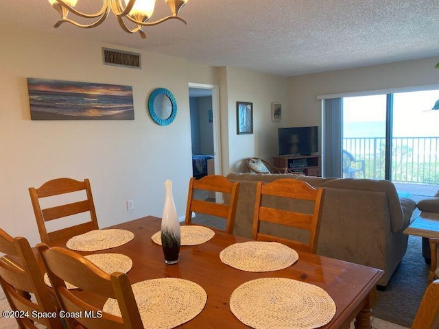 7520 Ridgewood Ave Unit 507, Cape Canaveral, FL 32920 - dining area with a chandelier, a textured ceiling, and wood finished floors
