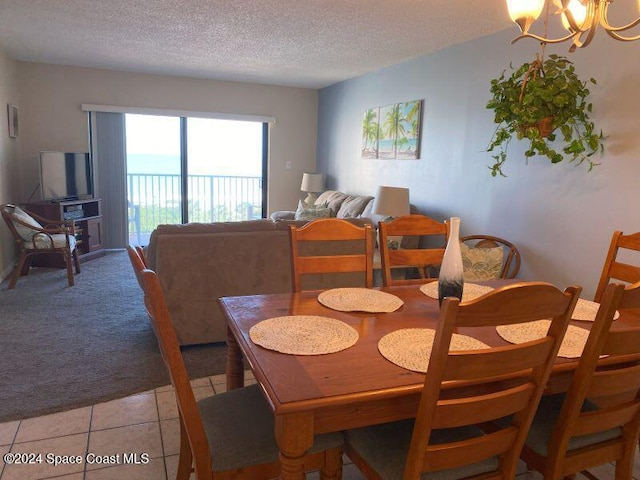 7520 Ridgewood Ave Unit 507, Cape Canaveral, FL 32920 - dining room with a textured ceiling, a chandelier, light carpet, and light tile patterned floors