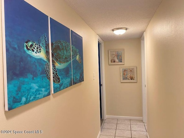 7520 Ridgewood Ave Unit 507, Cape Canaveral, FL 32920 - hallway featuring a textured ceiling, tile patterned floors, and baseboards