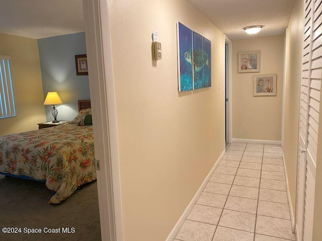 hallway featuring a textured ceiling and light tile patterned floors