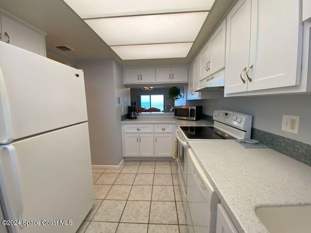 7520 Ridgewood Ave Unit 507, Cape Canaveral, FL 32920 - kitchen featuring white appliances, under cabinet range hood, white cabinetry, light countertops, and light tile patterned floors
