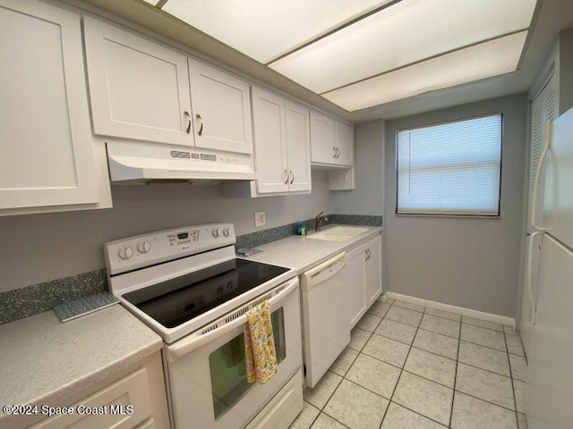 7520 Ridgewood Ave Unit 507, Cape Canaveral, FL 32920 - kitchen featuring white appliances, under cabinet range hood, baseboards, and white cabinetry