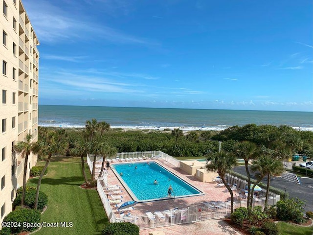 view of swimming pool with a beach view, a patio area, a yard, and a water view