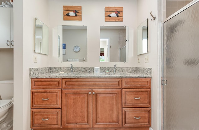 bathroom featuring an enclosed shower, vanity, and toilet