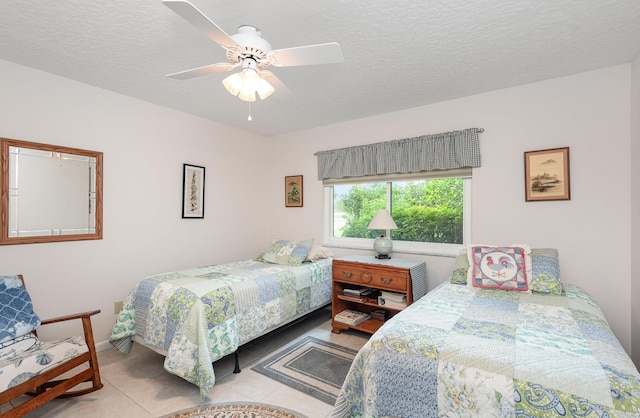 tiled bedroom with a textured ceiling and ceiling fan