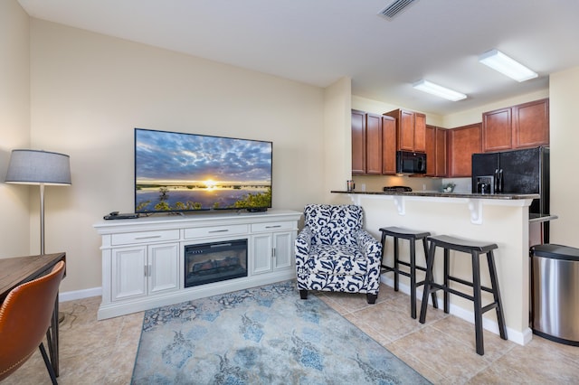 kitchen with kitchen peninsula, a breakfast bar area, and black appliances