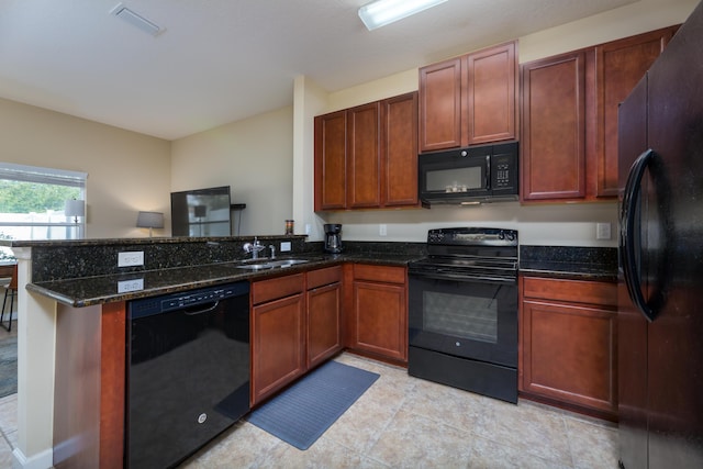 kitchen featuring kitchen peninsula, dark stone countertops, sink, and black appliances