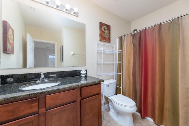 bathroom with tile patterned flooring, vanity, and toilet