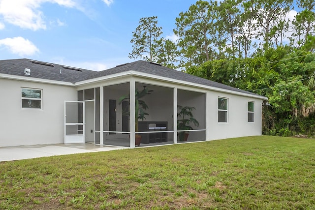 back of property with a patio area, a sunroom, and a yard