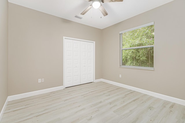 unfurnished bedroom with light hardwood / wood-style flooring, a closet, and ceiling fan