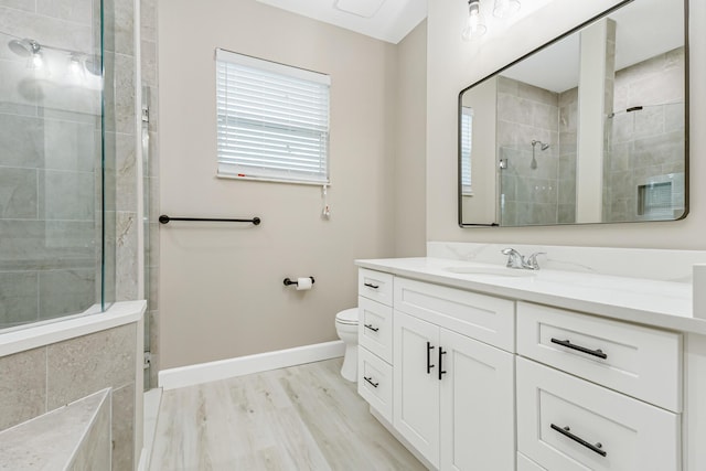 bathroom featuring vanity, toilet, tiled shower, and hardwood / wood-style flooring