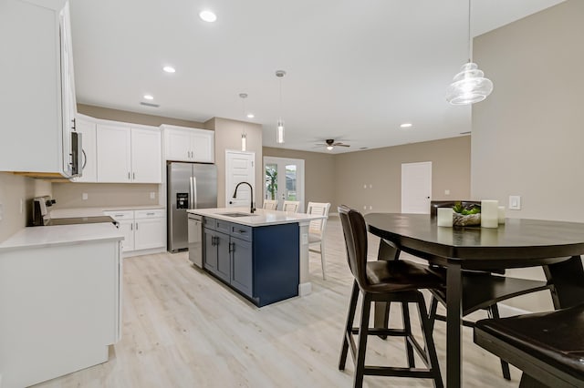 kitchen featuring white cabinetry, pendant lighting, appliances with stainless steel finishes, and sink