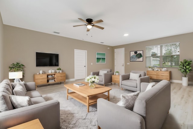 living room featuring light hardwood / wood-style flooring and ceiling fan