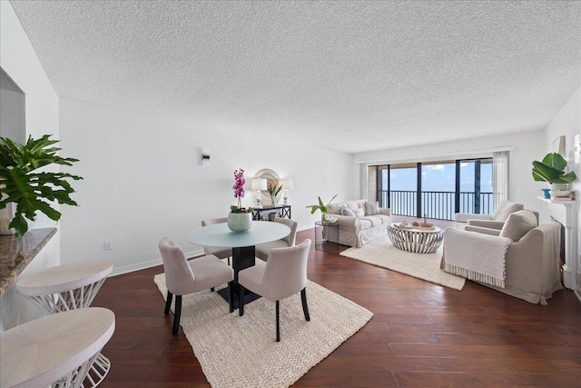 dining space featuring dark hardwood / wood-style flooring and a textured ceiling