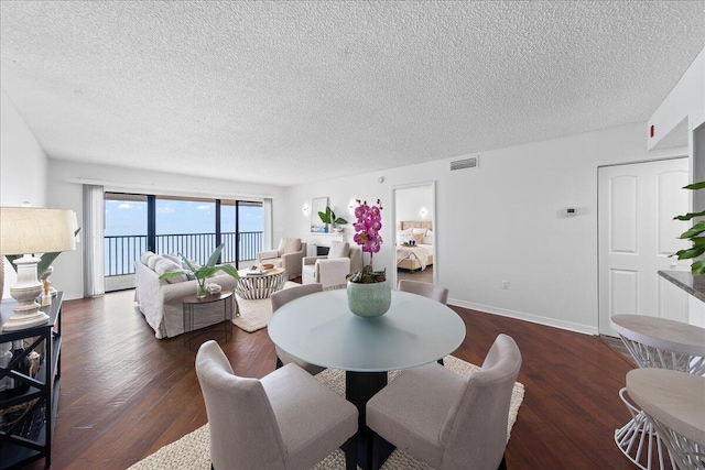 dining space featuring dark hardwood / wood-style floors and a textured ceiling