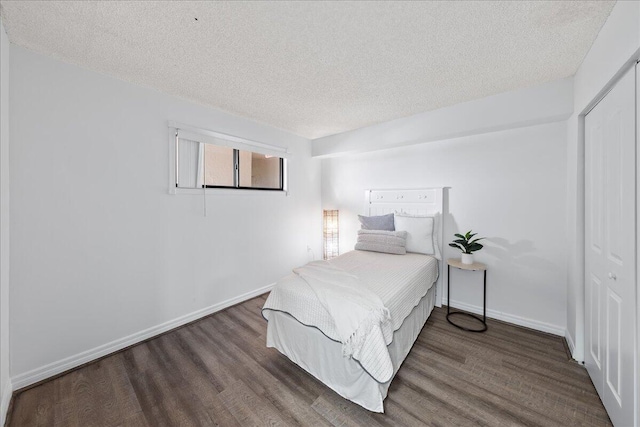 bedroom featuring dark hardwood / wood-style flooring, a closet, and a textured ceiling