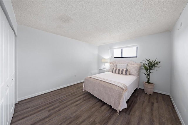 bedroom featuring a closet, a textured ceiling, and dark wood-type flooring