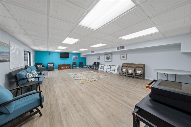 interior space with a paneled ceiling and hardwood / wood-style floors