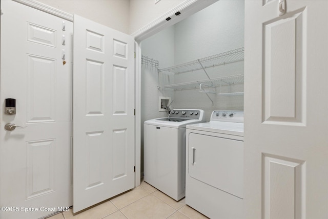 laundry room with washing machine and dryer and light tile patterned floors