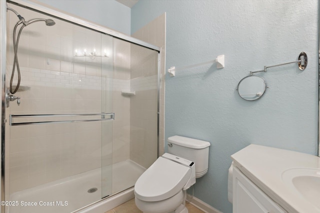 bathroom featuring vanity, a shower with door, and toilet