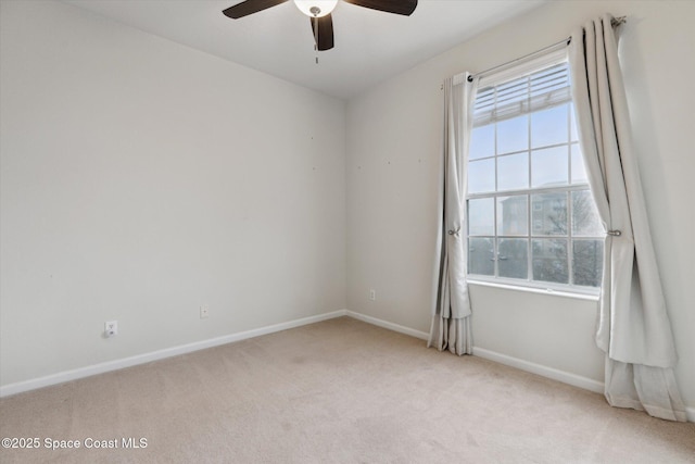 carpeted spare room with a wealth of natural light and ceiling fan